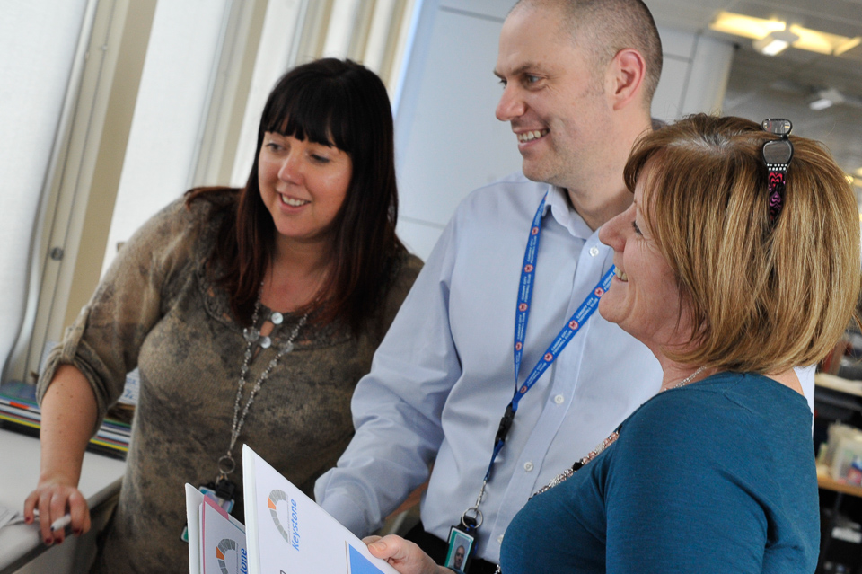 DfT HR team of two women and one man, smiling together.