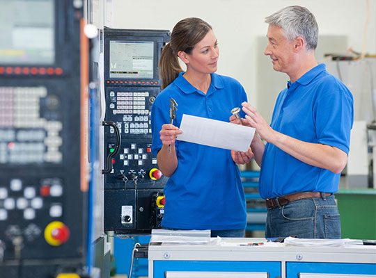 Two colleagues discussing tools in production at VCA.