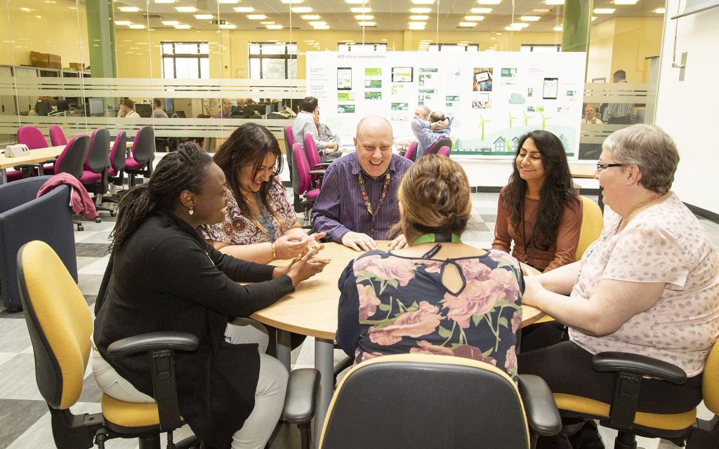 A diverse group of DfT staff sitting around an office table.