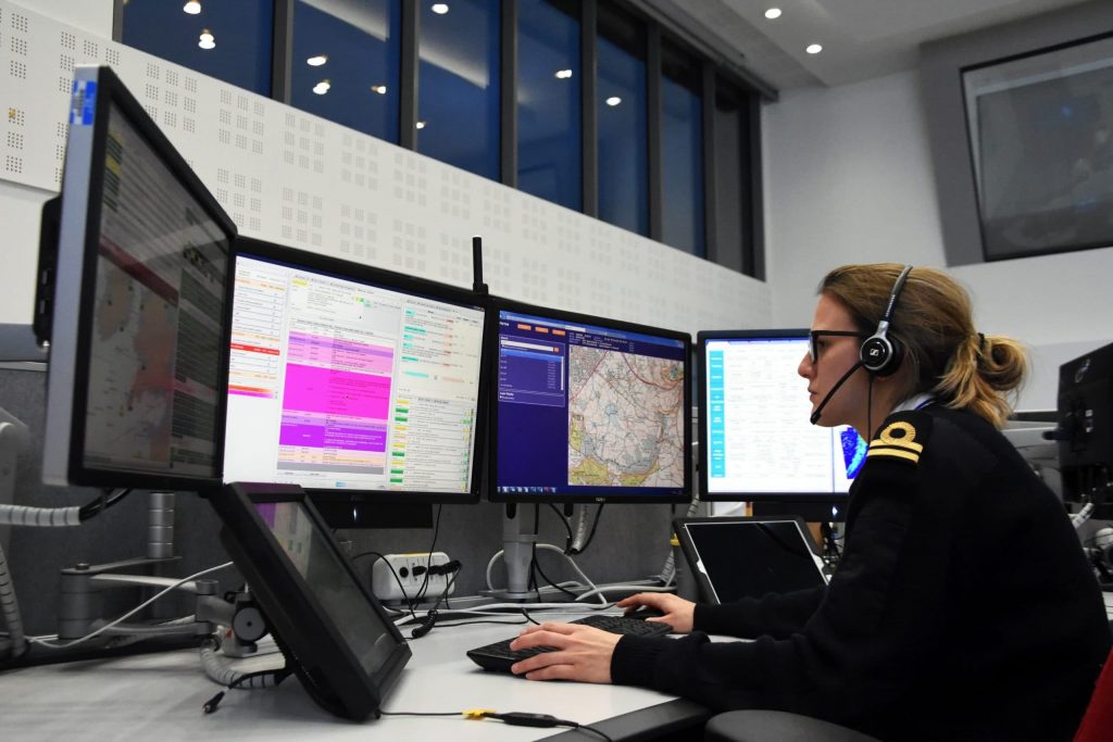 Female coastguard working at computer at an MCA office.